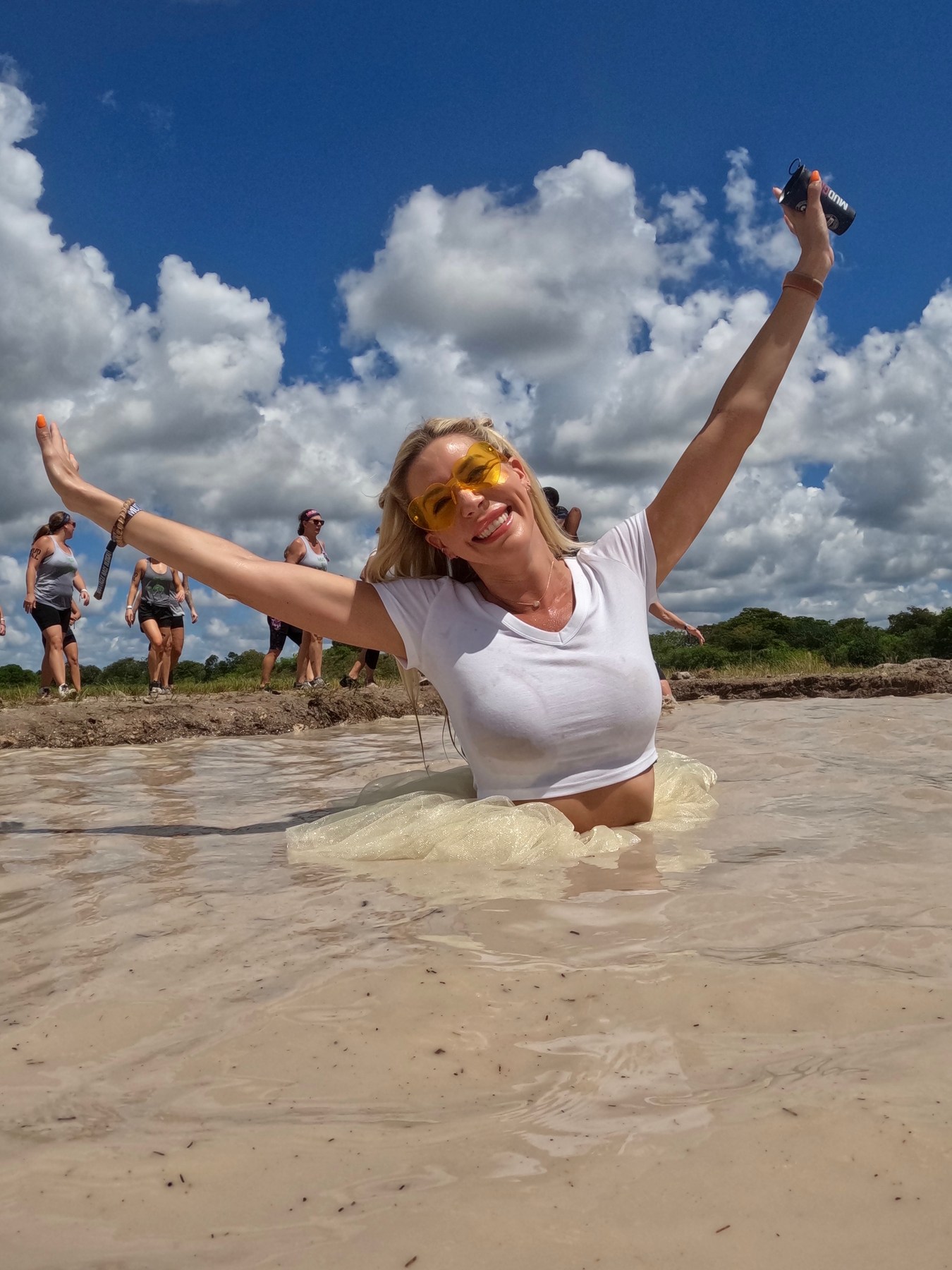 Playful outdoor moment in shallow water with arms raised